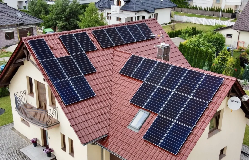 Dom jednorodzinny z instalacją fotowoltaiczną na dachu z czerwonej dachówki